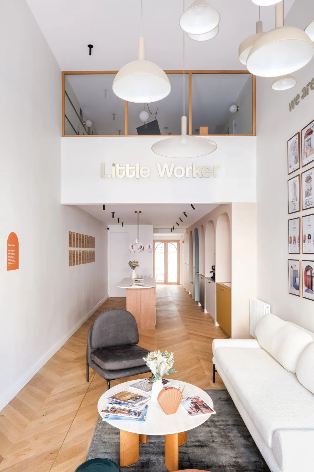 Boutique Little Worker à Lyon : double hauteur sous l'enseigne, parquet à chevrons, salon et cuisine — un Passage
