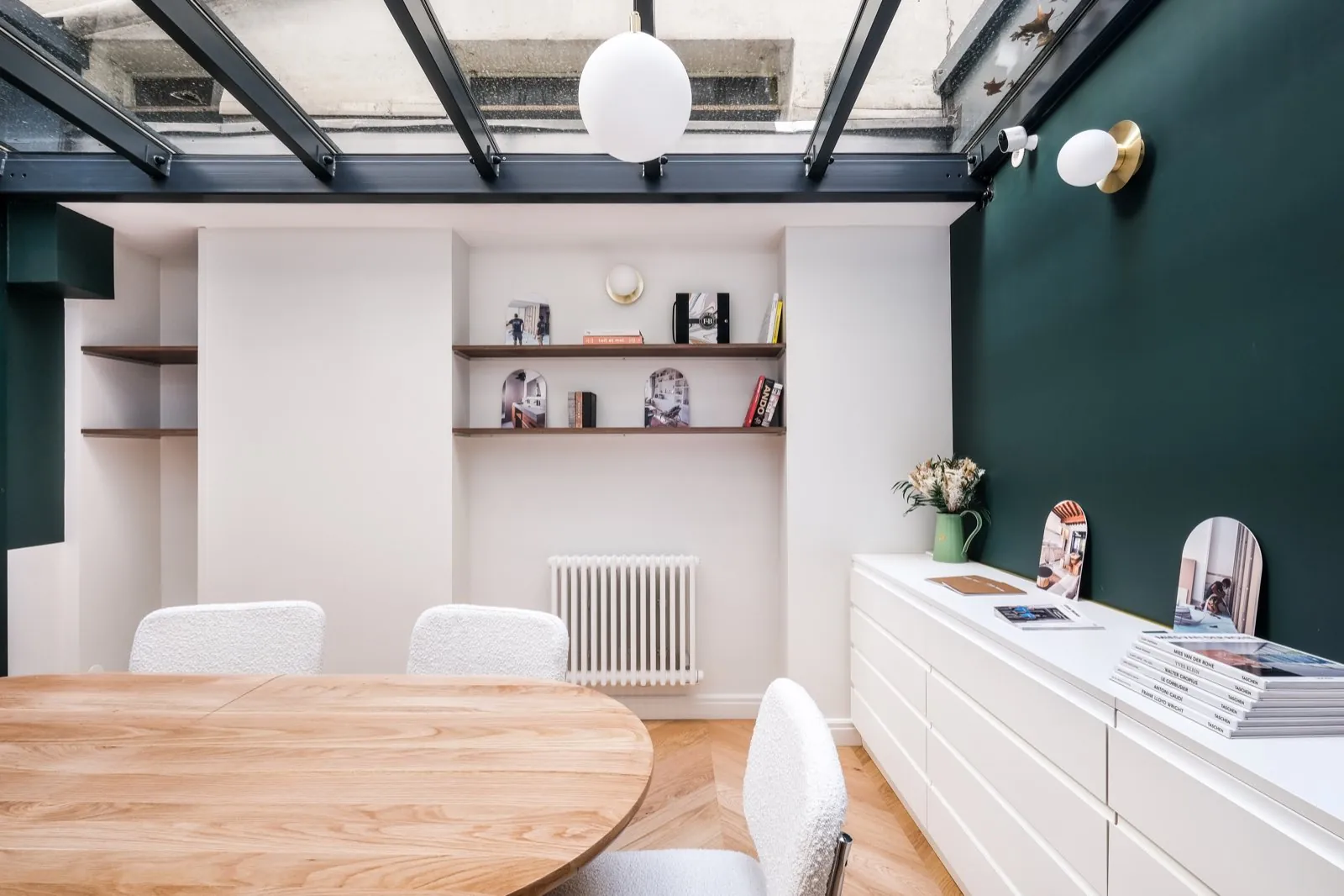 Salle de réunion sous verrière : étagères, buffet blanc et mur vert forêt — Passage de Lyon