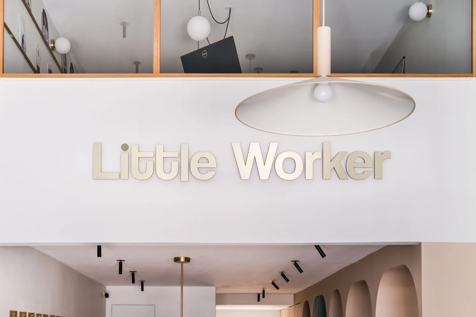 Détail de l'enseigne dorée Little Worker sous la mezzanine vitrée — Passage de Lyon