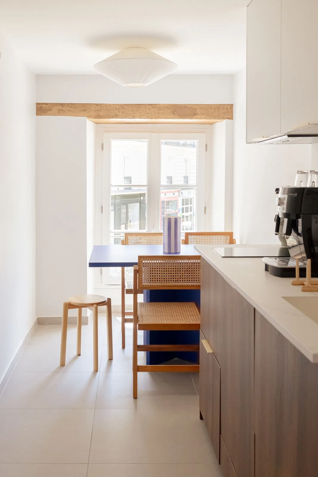 Cuisine partagée : table bleue, chaises cannées, îlot en bois et machine à café — Le Passage de Nantes